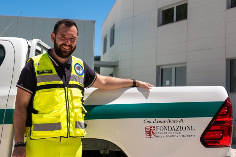 Il presidente accanto alla fiancata del pickup, dove è applicato l'adesivo «Con il contributo di Fondazione Cassa di Risparmio della Provincia di Macerata»