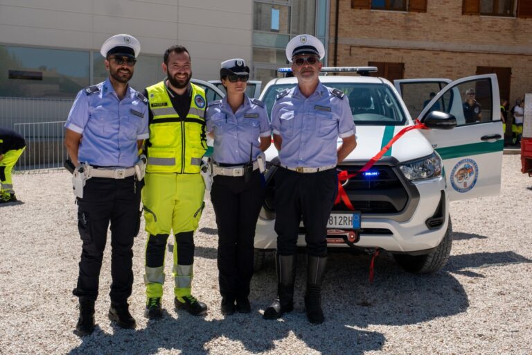 Tre agenti della Polizia Locale e un volontario davanti al pickup con il nastro rosso
