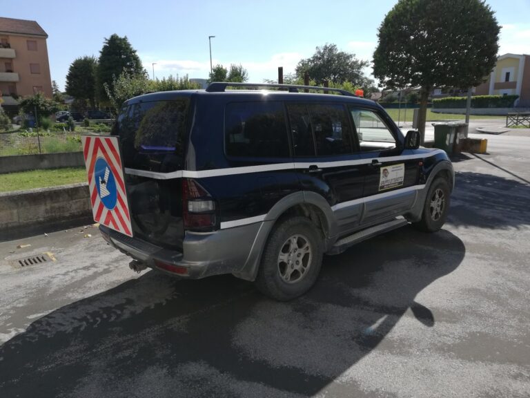 Il fuoristrada visto da dietro, con il pannello segnaletico a strisce bianche e rosse montato sul portellone