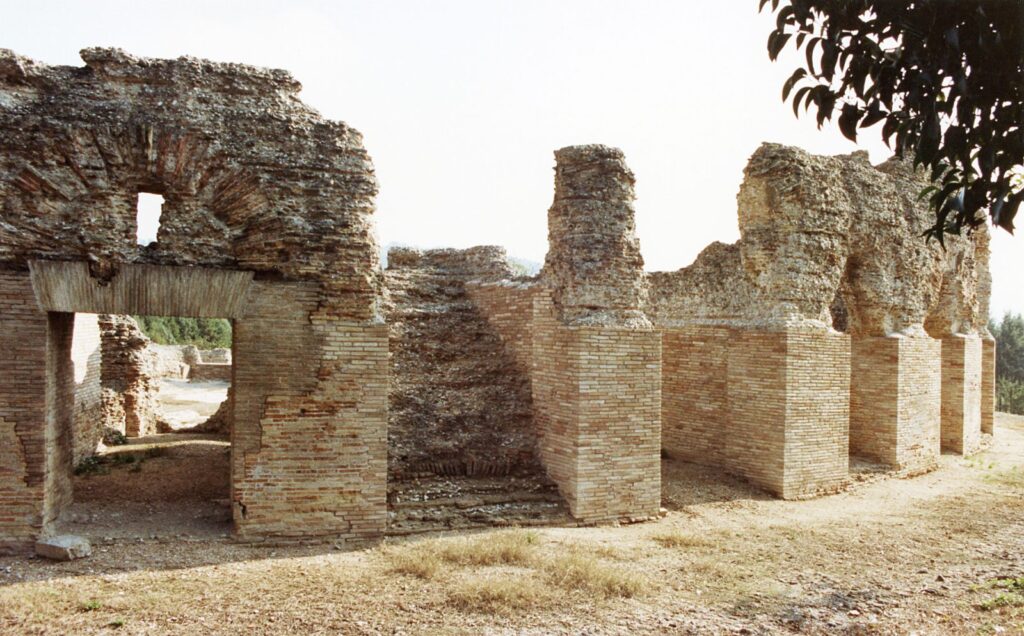 I piloni in mattoni del teatro romano di Helvia Recina visti da vicino, con l'arco di un passaggio voltato in primo piano