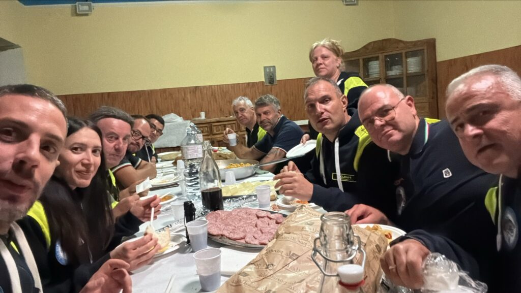 I volontari del Gruppo CB Tigrotto seduti a una lunga tavola apparecchiata, dopo il pellegrinaggio