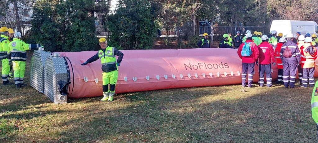 Un lungo tubo flessibile di colore rosa disteso sul prato e gonfio d'acqua, alto quanto la vita di un volontario che gli sta accanto per dare la misura; attorno, gruppi di soccorritori di varie associazioni